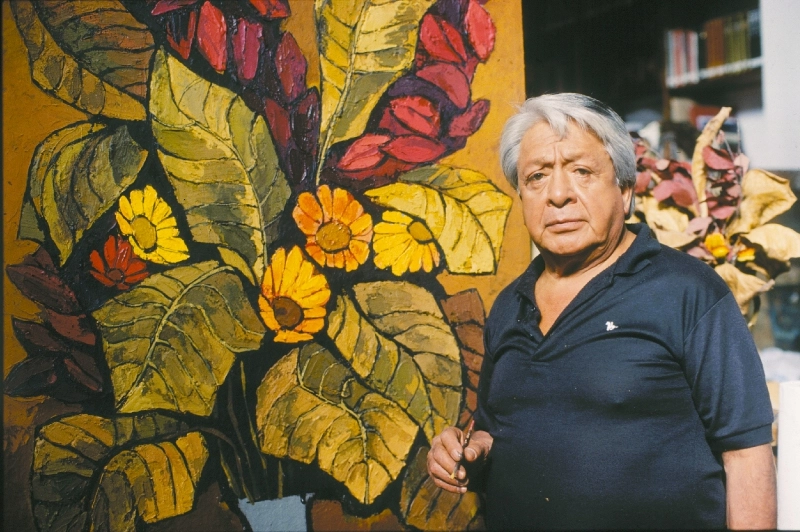 Artista Oswaldo Guayasamin posando junto a una de sus obras